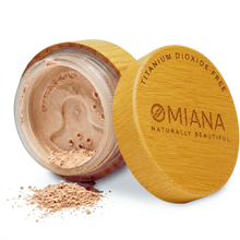 Open container of Omiana Mineral Loose Powder Makeup for sensitive skin with visible brand name on a white background